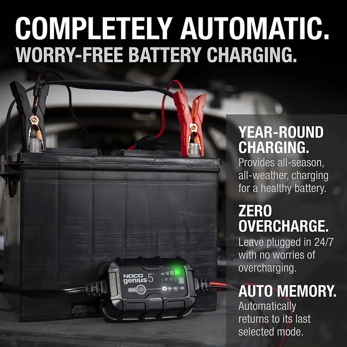 NOCO Genius 5 battery charger connected to a black lead-acid battery with red and black alligator clamps.