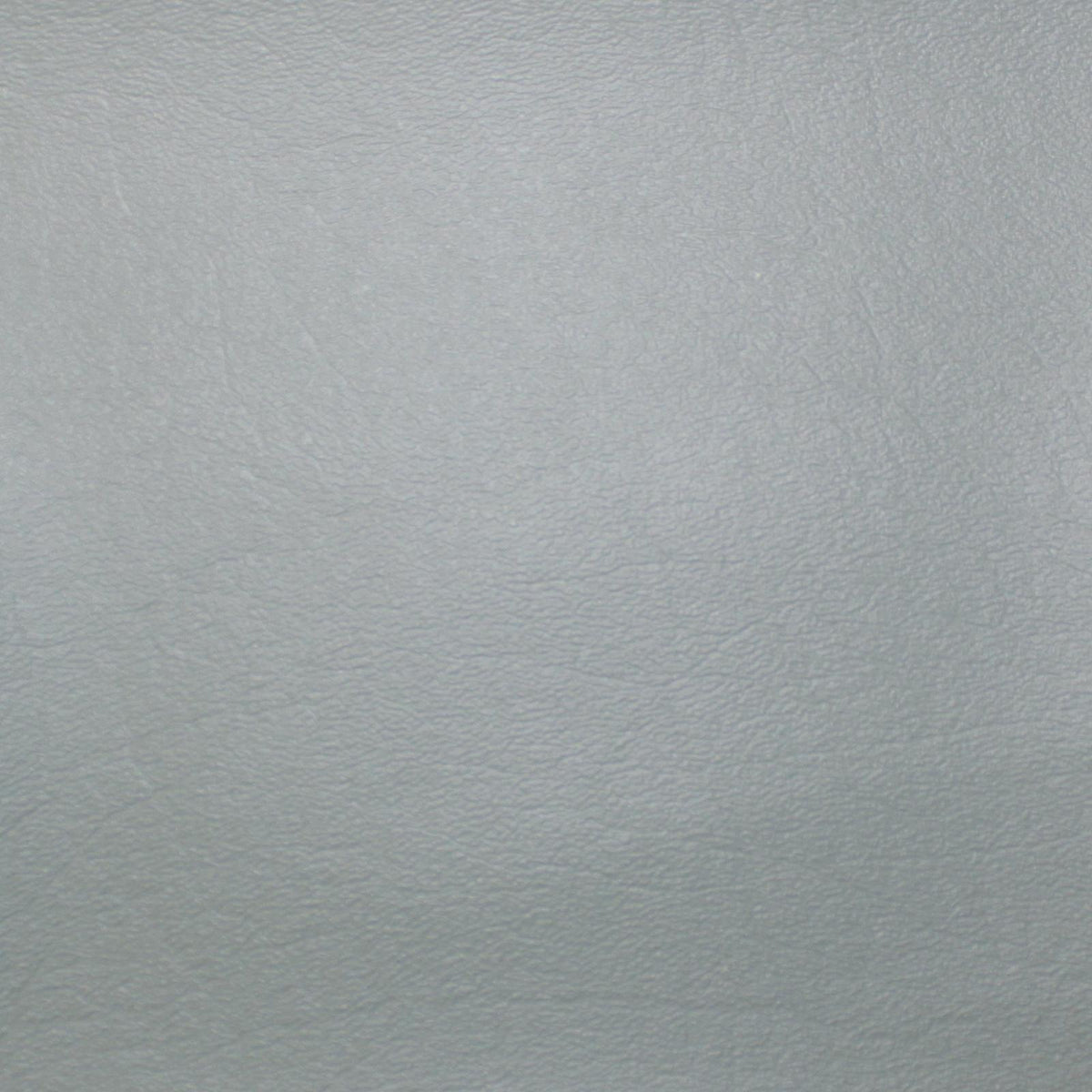 Close-up texture of black vinyl material used for tractor seat cushions.