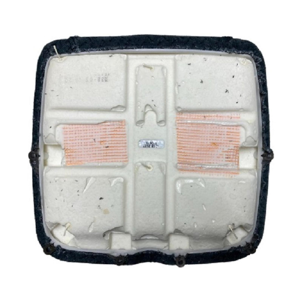 Underside of a black tractor seat cushion featuring a molded white foam base with reinforced mesh patches and mounting points.