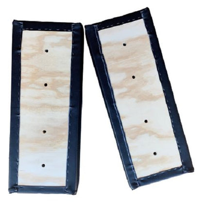 Black vinyl crawler seat armrest set with wooden backing and pre-drilled bolt holes for Caterpillar equipment.