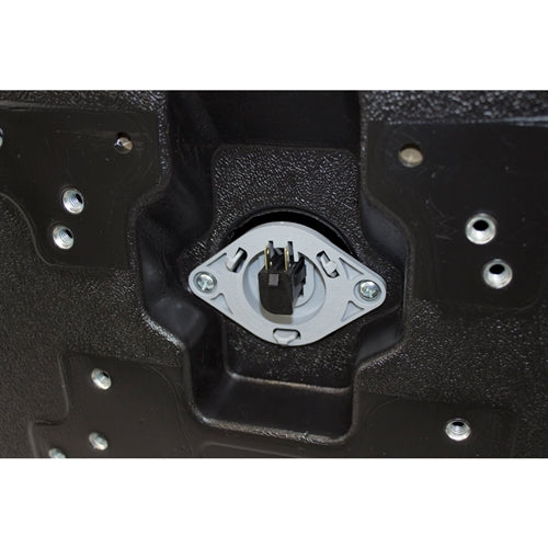Underside of a black plastic tractor seat with a central safety switch and multiple mounting hole patterns.