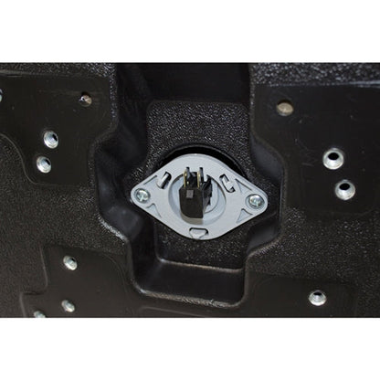 Black plastic tractor seat underside with integrated safety switch and multiple mounting bolt patterns.